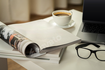 Modern Workspace With Laptop, Glasses, and Magazines