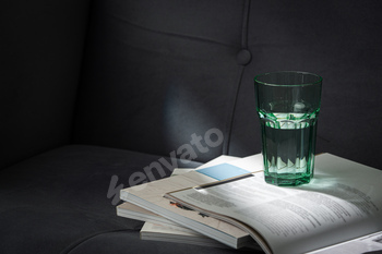 Glass of Water on Open Magazines Resting on a Couch