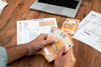 Middle aged man holds euros bills fan for utility bills payment at office table money amount