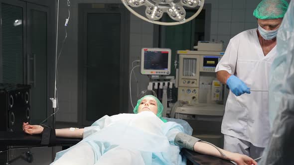 Anesthesiologist Prepares Female Patient for Surgery