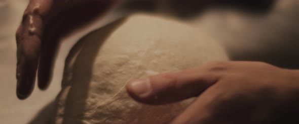 Chef checking the shape of the traditional pizza dough. Close up, slow motion