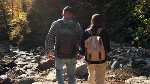 Pair of Backpackers are Exploring Beautiful Forest at Sunny Autumn Day Rear View Family Weekend at