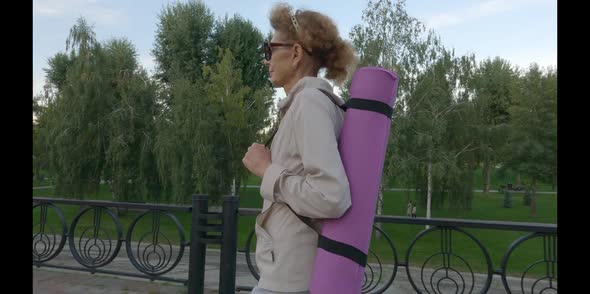 Happy Senior Woman Going on Sport Training Carry Yoga Mat