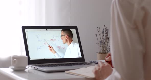 Distance learning. A male teacher at the laptop screen conducts an online lesson.