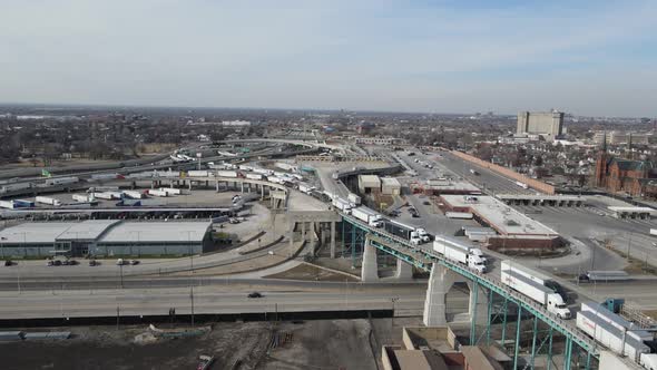 Convoy of trucks slowly driving over Ambassador bridge to cross USA - Canada border. Detroit citysca