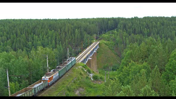 Aerial View of a Train Crossing a Railway Bridge Over a River in Summer