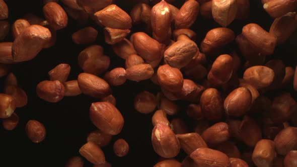 A Pile Peanuts Thrown In The Air Flying In High Speed On Black Background A Top View