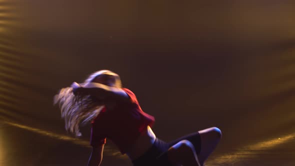 A Girl with Curly Hair Cheerfully Dances Funky Jazz in the Studio Against the Background of Lights