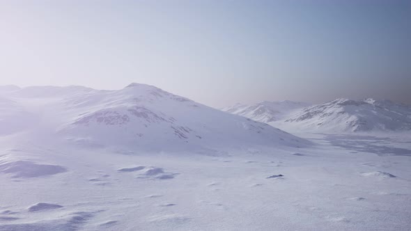Aerial Landscape of Snowy Mountains and Icy Shores in Antarctica alt