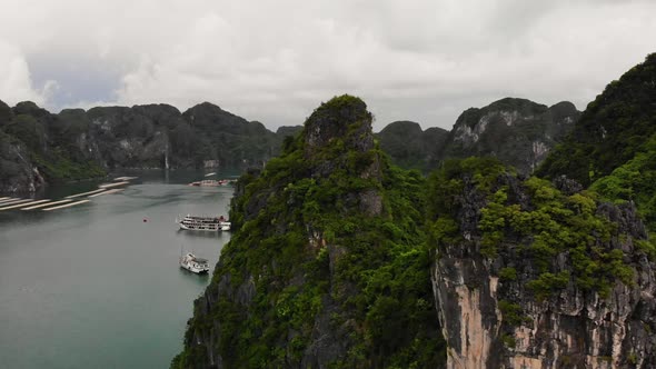 Panning shot of Halong Bay with limestone cliffs covered with foliage
