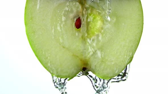 Super Slow Motion Detail Shot of Flowing Water From Apple Slice on White Background at 1000Fps