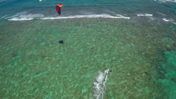 Aerial view of a man kitesurfing in Hawaii.