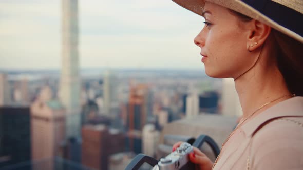 Beautiful girl with a retro camera at the view point