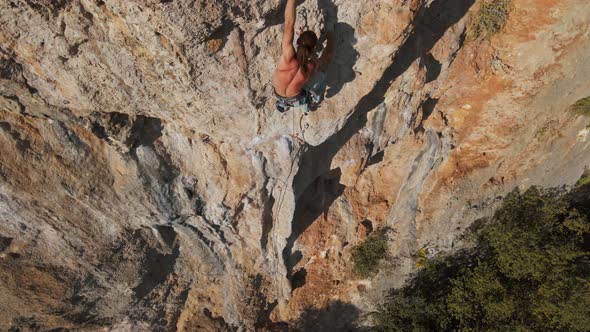 Aerial Point of View From Drone of Strong Muscular Man Climbs Challenging Rock Climbing Route