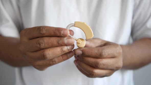 Men Holding Hearing Aid Equipment Close Up