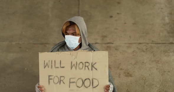 Homeless man holding will work for food label