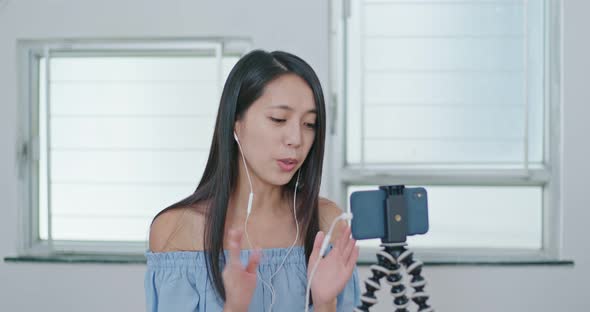 Woman having live stream on cellphone at home