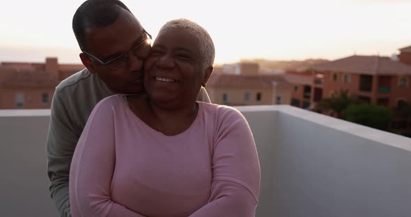 Senior couple having tender moment on patio home at sunset