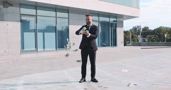 Successful Businessman in Suit Throwing Money Standing Near Office Building