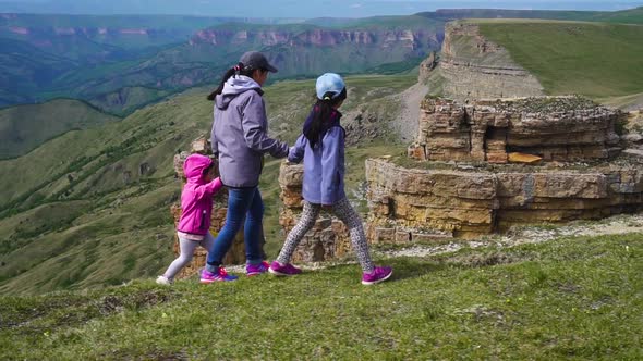 Asian Girl with a Child Walks High in the Mountains