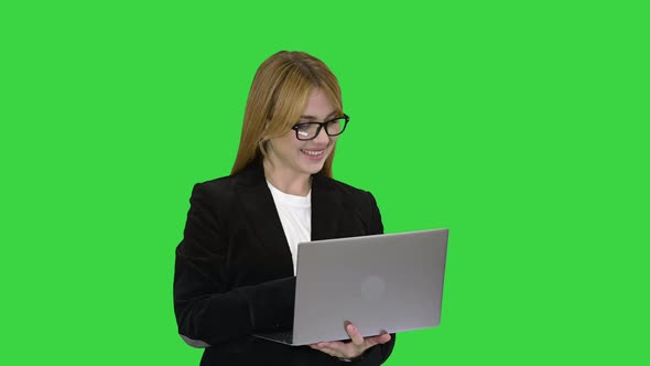 Business Woman Working on Laptop Smiling on a Green Screen, Chroma Key.