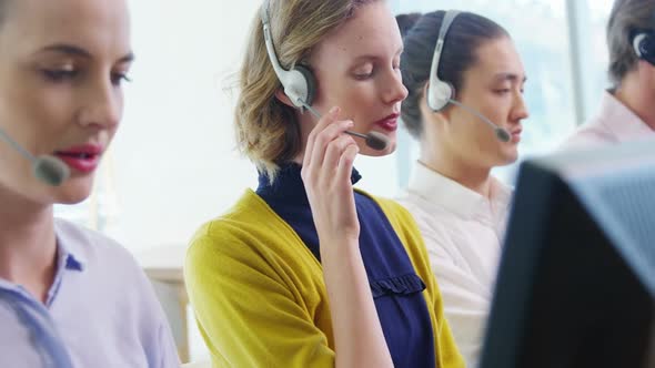 Team of customer service executives working at desk