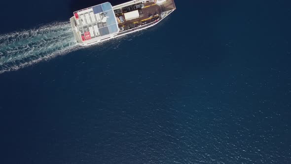 Aerial view above ferry boat with cars driving in the mediterranean sea, Greece.