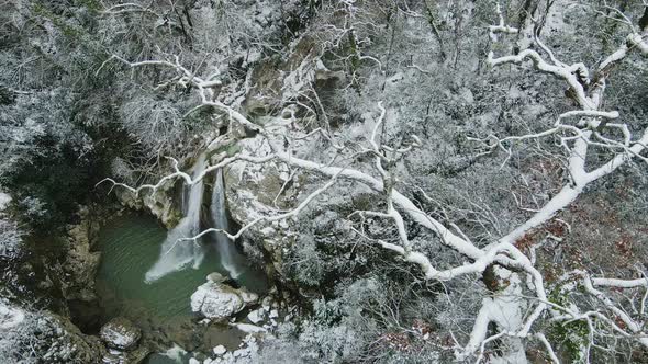 Waterfall Flowing From White Rocks Into a Lake in the Forest