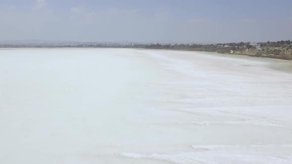 Aerial drone shot near the coast flying over a large salt lake in Cyprus