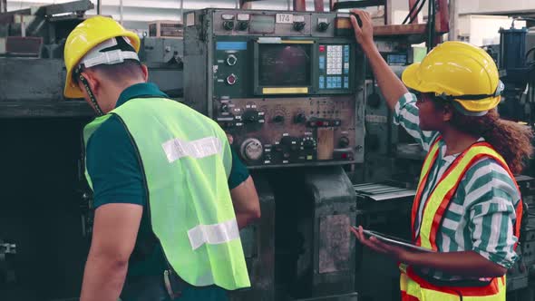 Group of Factory Workers Using Machine Equipment in Factory Workshop