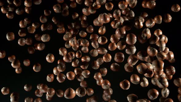 Super Slow Motion Shot of Flying Whole Hazelnuts Towards Camera Isolated on Black at 1000Fps