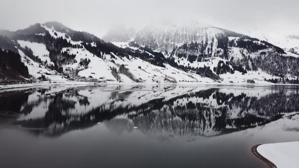 Wonderful drone flight over a reflective mountain lake in Switzerland.