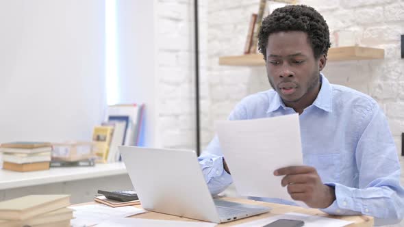 Worried African Man Reading Documents