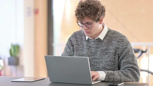 Positive Young Man with Laptop Showing Thumbs Up