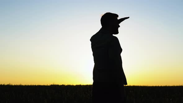 Silhouette of a Farmer Standing in a Wheat Field