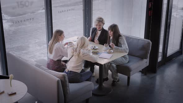 The Friends Met in a Cafe and are Glad That They Have Gathered