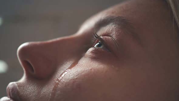 Close-up of the Crying Face of a Young Girl, From Whose Eyes Two Tears Flow, The Girl Is Lying on