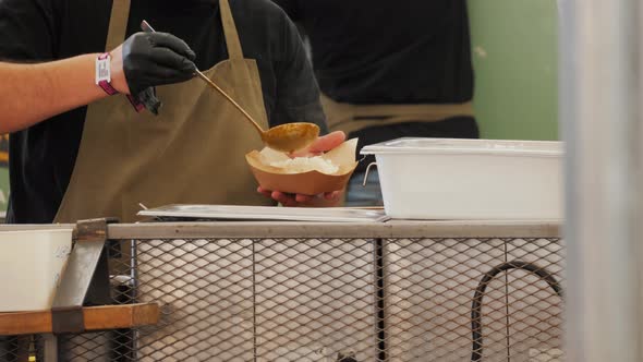 Person Chef Man in Gloves Cooking Nachos in Food Street Festival Truck