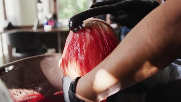 Rear view woman having her hair washed by a hairdresser