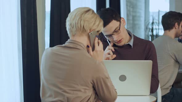 Two Coworkers Working Together, Having Phone Calls in the Cafe