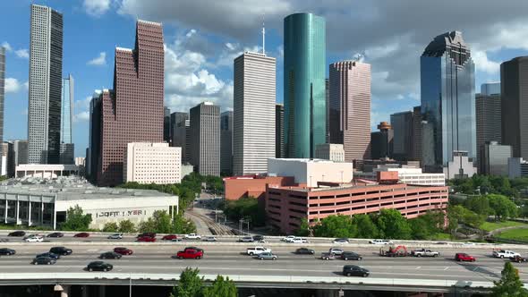 Interstate 45 passes by downtown Houston Texas during rush hour. Blue sky and dramatic clouds. Aeria