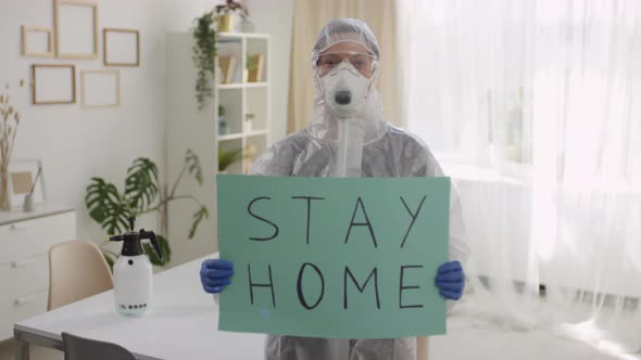 Person in Protective Gear Holding Sign