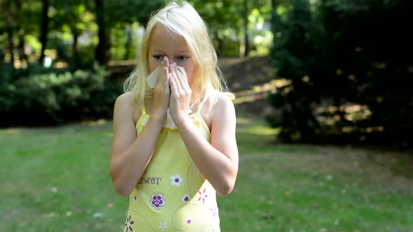 Little Cute Girl Blows Her Nose in the Park - She Has an Allergy