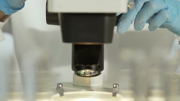 Female Researcher Studying Sample Slide, Moving It to See Better, Medical Test