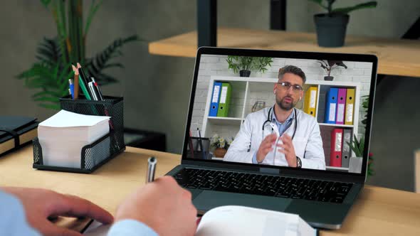 Man Doctor in Laptop Screen Tells Consults Online Video Call Computer Webcam