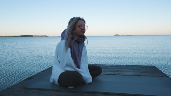 Girl sitting on the pier and talking. Slow motion