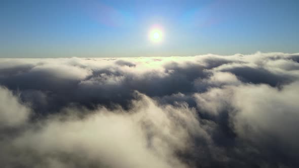 Aerial View From Airplane Window at High Altitude of Dense Puffy Cumulus Clouds Forming Before