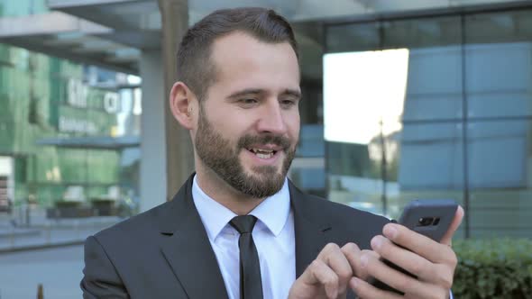Beard Man Excited for Success While Using Smartphone