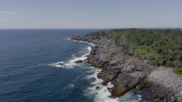 Drone shot flying over waves on the rocky coast on a small island in Maine