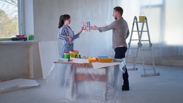 Angry Couple Yell at Each Other During Renovation Irritated Young Woman with Swatches in Her Hands